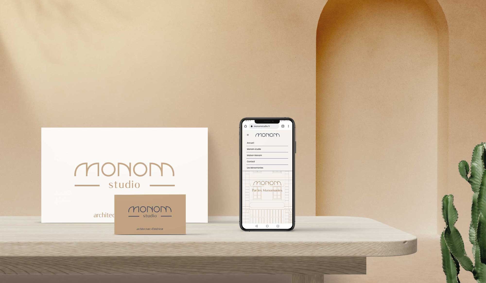 Mise en situation par mock-up du site internet et de l'identité visuelle de Monom sur supports imprimés et smartphone.